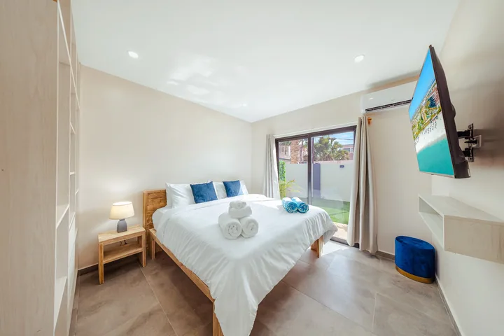 White linens on a comfortable double bed with large patio door