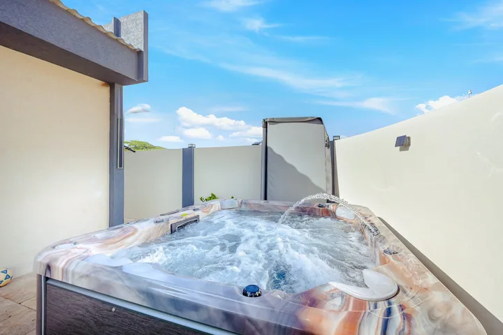 Outdoor hot tub with jets operating in a sunny courtyard