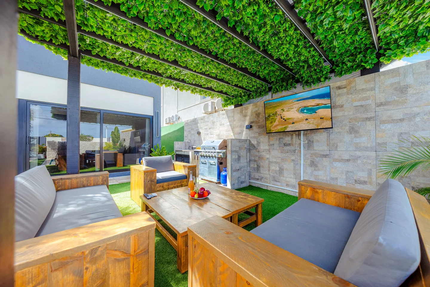 Wooden seating under a shaded outdoor lounge pergola at Sea La Vie