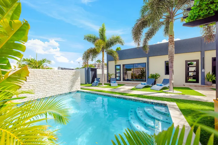 Lush planting beside blue pool with tropical palms