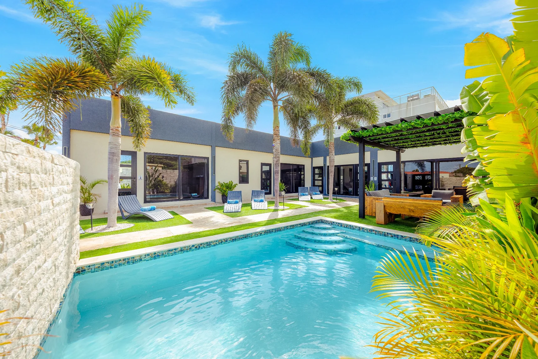 Shared palm-lined swimming pool at Sea La Vie