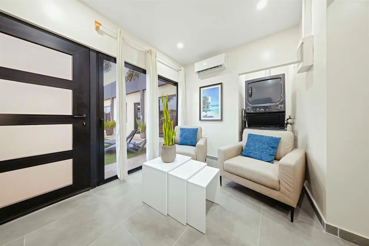 Two cream lounge chairs and nesting tables in Sea La Vie Suite 2.