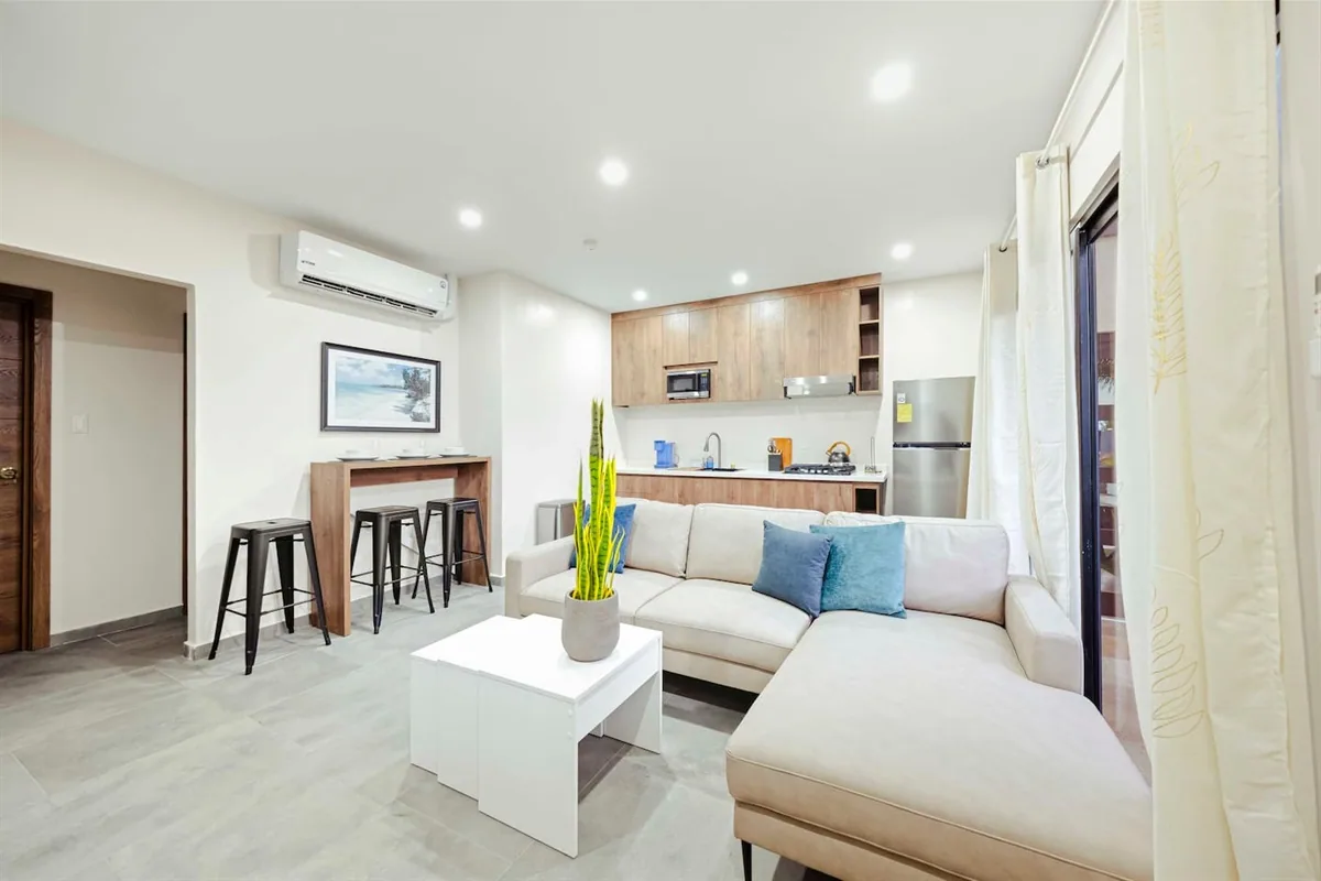 Open-plan living area with sofa and kitchen in Sea La Vie Suite 3.